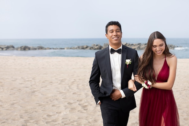 Couple en vêtements de bal de fin d'année à la plage