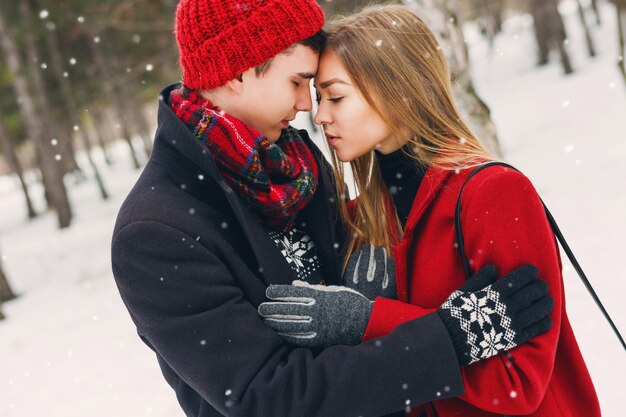 Couple en vêtements d'hiver étreignant un jour de neige