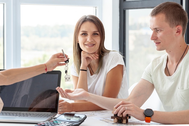 Couple vue de face acceptant les clés pour leur nouvelle maison