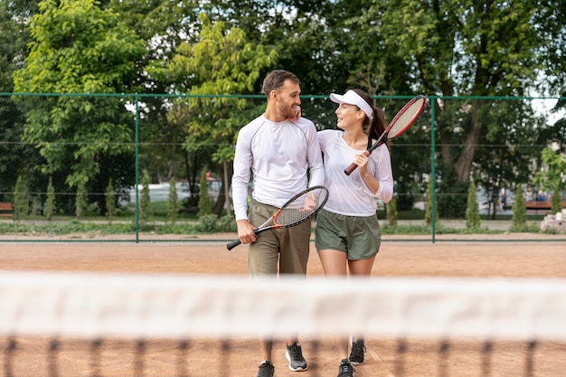 Couple vue de face sur un court de tennis