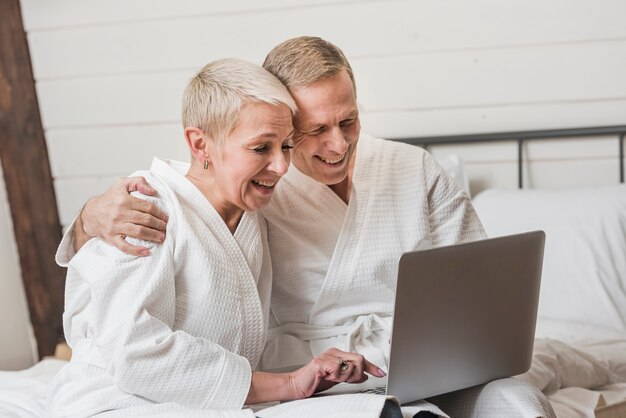 Couples mûrs, regarder ensemble, sur, leur, ordinateur portable, chez soi
