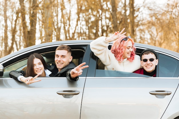 Couples, poser dans fenêtre voiture, et, montrer, geste paix