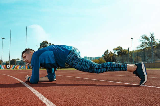 Photo gratuite coureur homme, étirage, jambes, préparer, exécuter, formation, sur, stade, pistes, faire