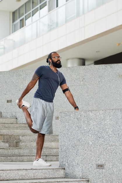 Coureur masculin, étirage, dehors