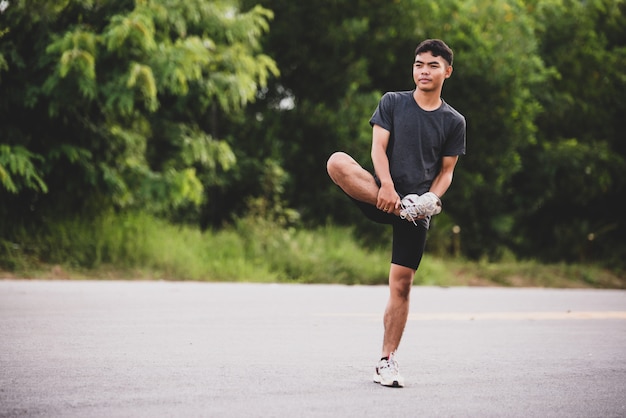 Coureur masculin faisant des exercices d'étirement, se préparant à l'entraînement