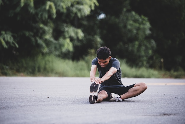 Coureur masculin faisant des exercices d'étirement, se préparant à l'entraînement