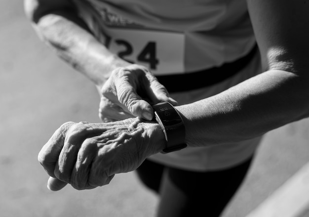 Photo gratuite coureur senior à l'aide d'un tracker de fitness