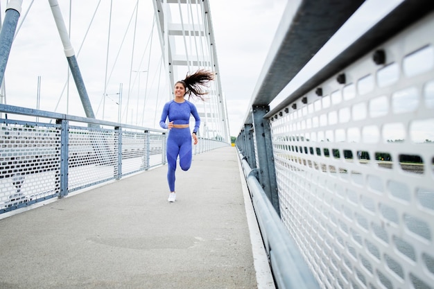 Coureuse avec corps et jambes solides qui traversent le pont et s'entraînent