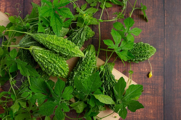 Les courges amères crues mises sur une planche à découper en bois