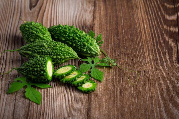 Les courges amères crues mises sur le plancher en bois