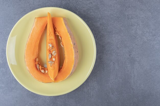 Courgettes tranchées sur une assiette, sur la surface en marbre.