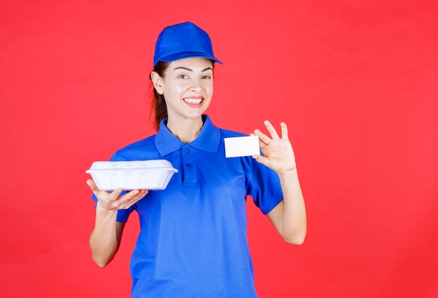 Courier Femme tenant une boîte à emporter blanche et présentant sa carte de visite.