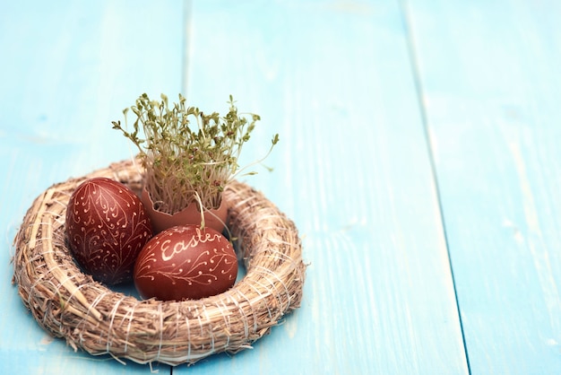 Photo gratuite couronne de paille et oeufs de pâques