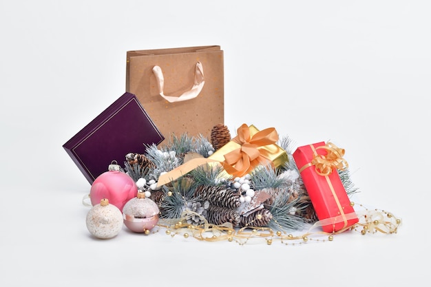 Couronne de pomme de pin entourée de coffrets cadeaux emballés et de boules de Noël