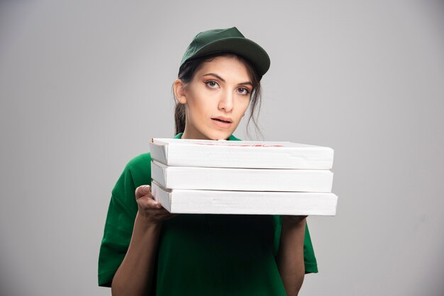 Courrier femelle tenant des boîtes à pizza