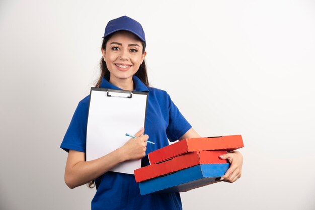 Courrier féminin positif avec carton de pizza et presse-papiers