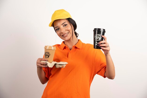 Courrier de femme souriante donnant deux tasses de café
