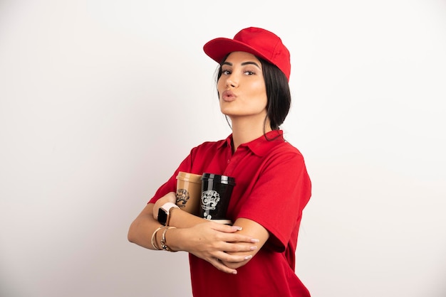 Courrier de femme tenant fermement deux tasses de café. Photo de haute qualité