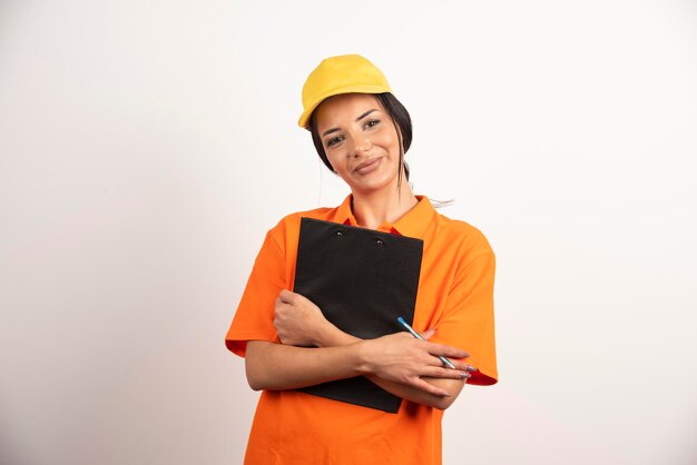 Courrier de jeune femme tenant le presse-papiers sur le mur blanc.