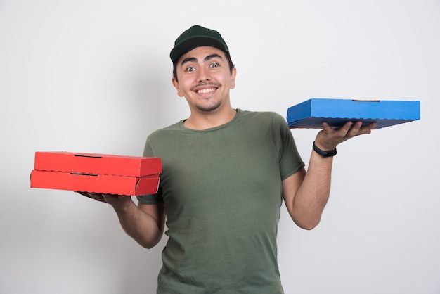 Courrier positif transportant trois boîtes de pizza sur fond blanc.