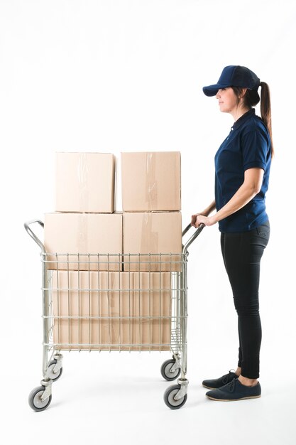 Courrier en poussant le camion de main avec une pile de boîtes