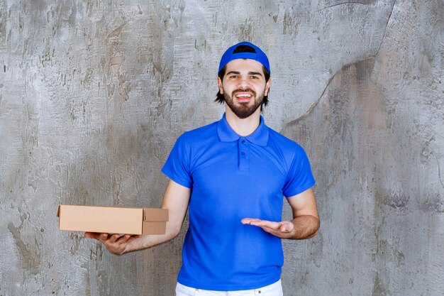 Courrier en uniforme bleu tenant une boîte à emporter