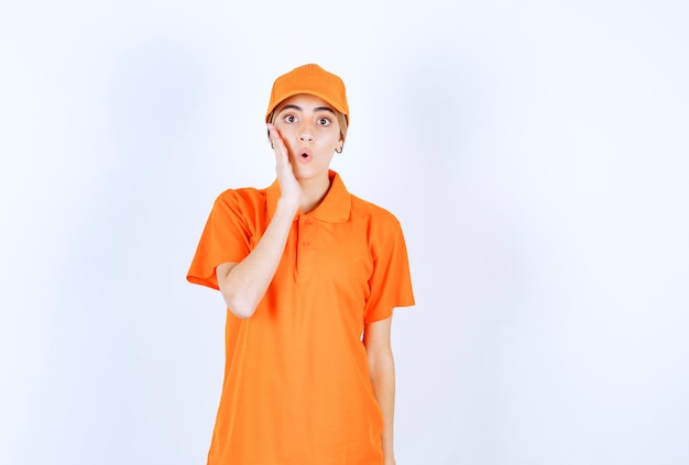 Le coursier féminin en uniforme orange a l'air terrifié et effrayé