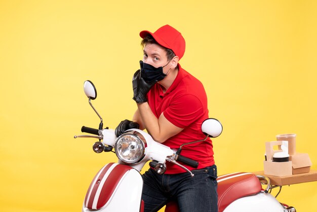 Coursier mâle vue de face en gants uniformes et masque sur jaune