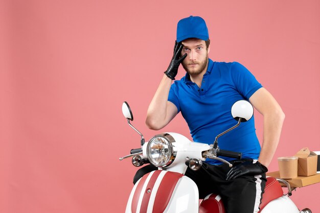 Coursier mâle vue de face en uniforme bleu sur le rose