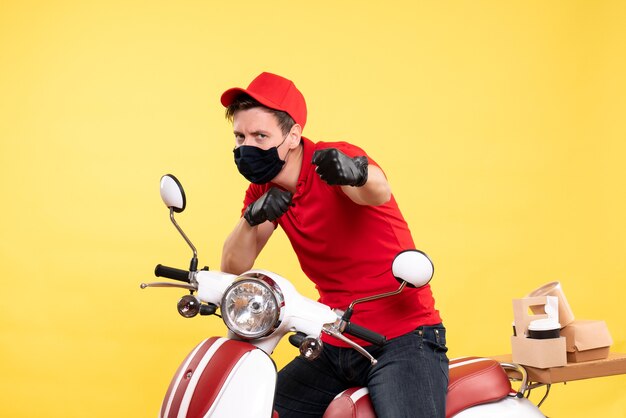 Coursier mâle vue de face en uniforme et masque sur jaune