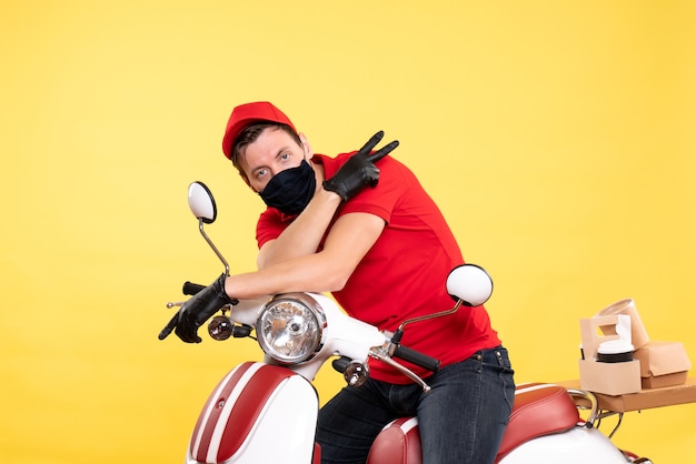 Photo gratuite coursier mâle vue de face en uniforme rouge et masque sur jaune