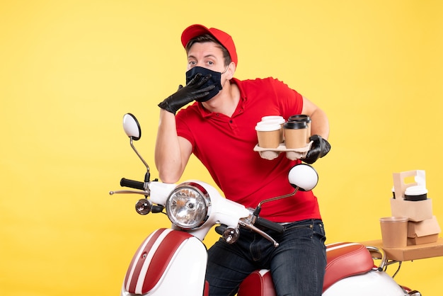 Coursier mâle vue de face à vélo en masque avec café sur jaune