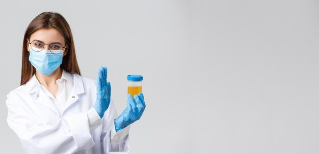Covid19 diagnostic de recherche médicale travailleurs de la santé et concept de quarantaine Médecin stagiaire en masque médical et gants clinique de laboratoire testant un échantillon d'urine montrent un geste de rejet et de refus
