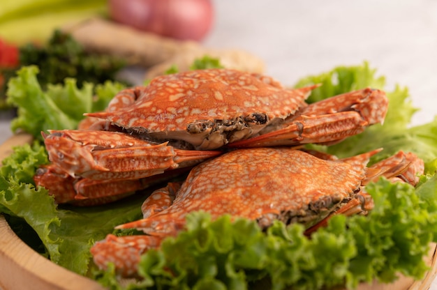 Un crabe est cuit sur de la laitue dans un plat.