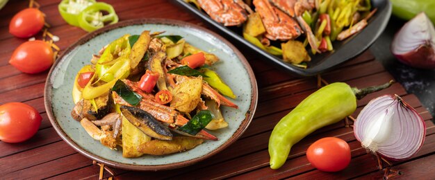 Crabe frit au curry en poudre dans une assiette avec poivrons et tomates.