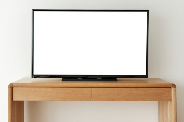 Écran de télévision intelligent blanc vierge sur une table en bois
