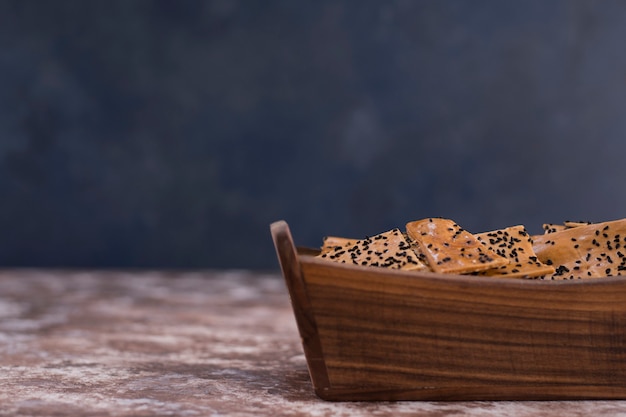 Craquelins au cumin noir sur eux dans un plateau en bois.