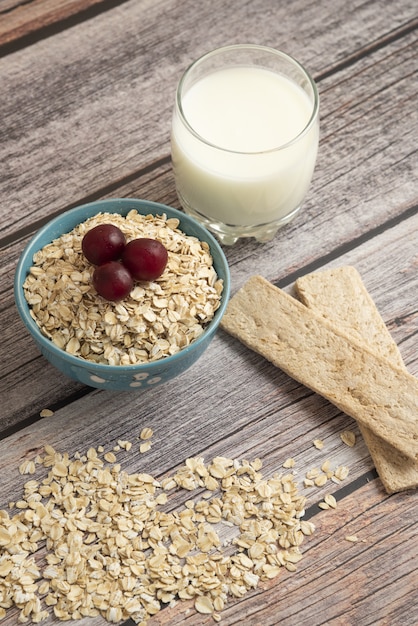 Craquelins à l'avoine, céréales aux fruits rouges et une tasse de lait sur la table