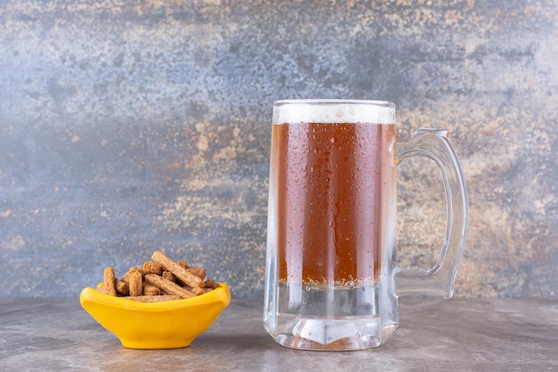 Craquelins et verre de bière froide sur table en marbre. photo de haute qualité