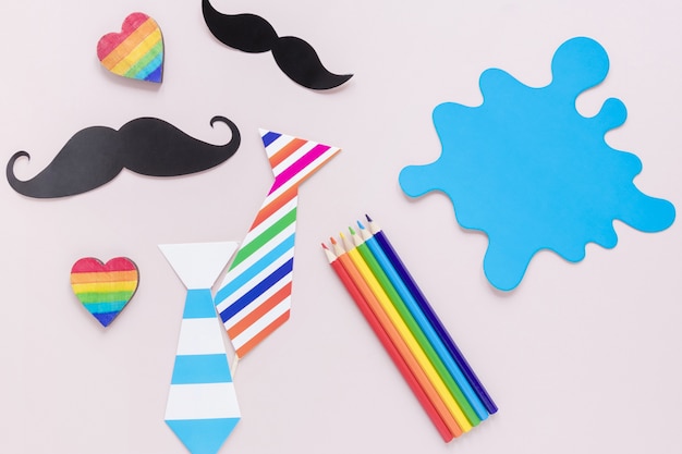 Photo gratuite cravate avec moustaches et crayons de couleur