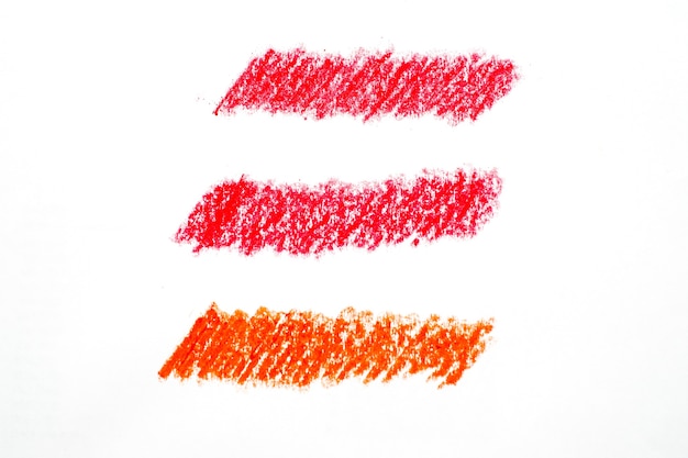 Crayon abstrait sur fond blanc. texture de gribouillis de crayon rouge. tache pastel de cire. c'est une main dessinée