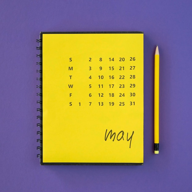 Crayon et calendrier jaune vue de dessus