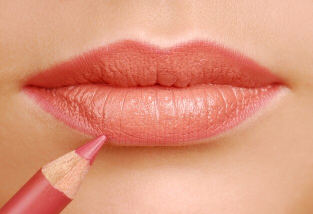 Crayon cosmétique rouge à lèvres. Outil de maquillage. Lèvres de la femme se bouchent