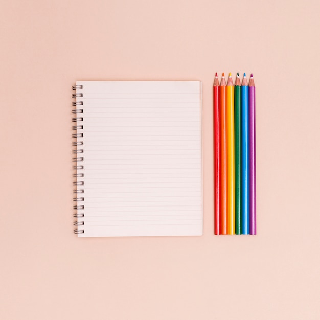 Crayons de couleur arc en ciel et cahier