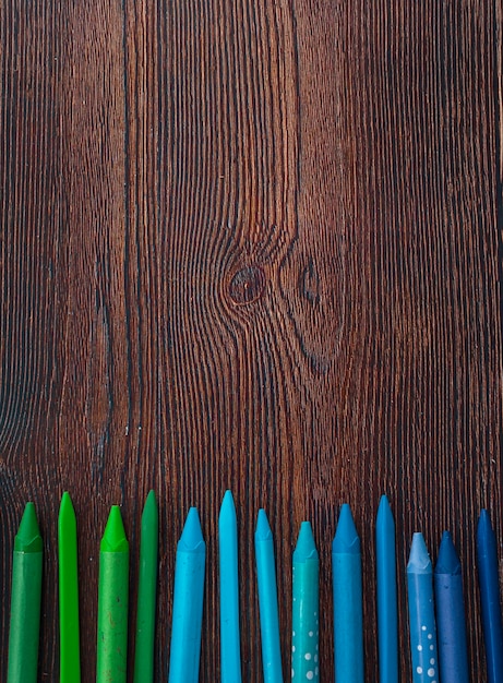 Photo gratuite crayons de couleur bleu et vert disposés en rangées sur une table en bois