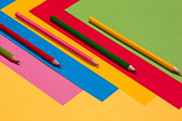 Crayons de couleur et feuilles de papier de couleur