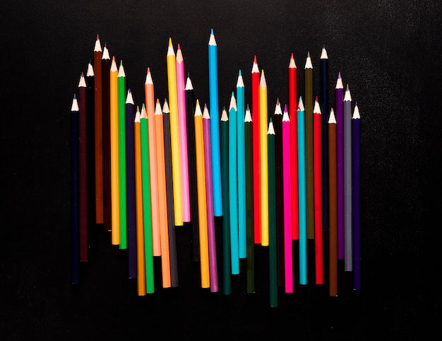 Photo gratuite crayons de couleurs vives placés sur fond noir