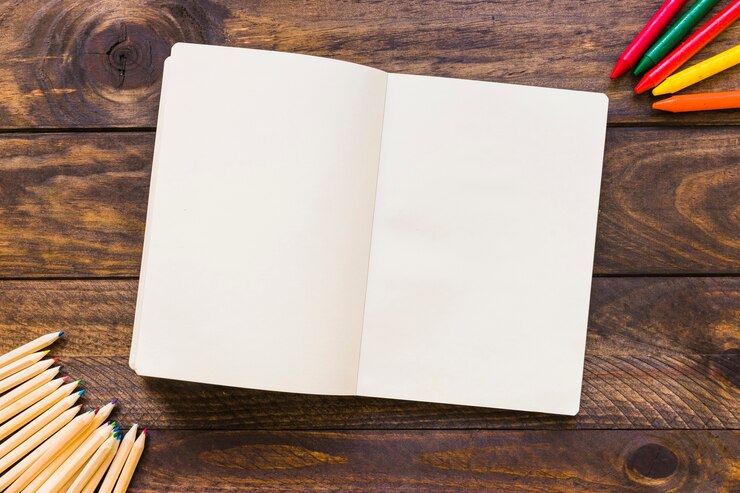Photo gratuit crayons et crayons près de cahier ouvert