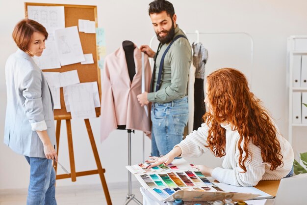Créateurs de mode travaillant en atelier avec forme de robe et palette de couleurs
