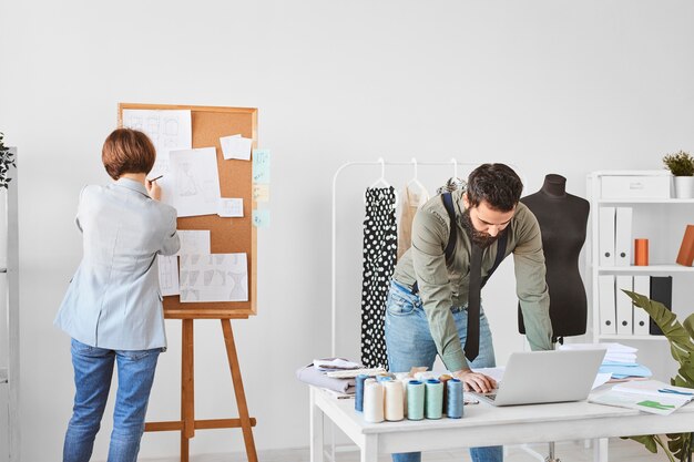 Créateurs de mode travaillant sur la ligne de vêtements en atelier